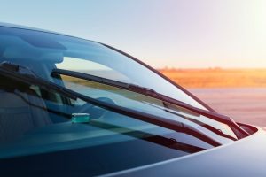 Clean car windshield with sunset reflection.